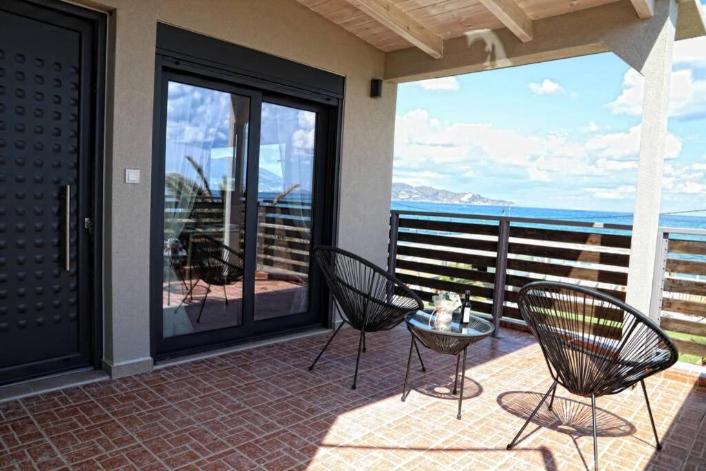 a patio with two chairs and a table on a balcony at Havana 2 Luxury sea and pool in Gázion