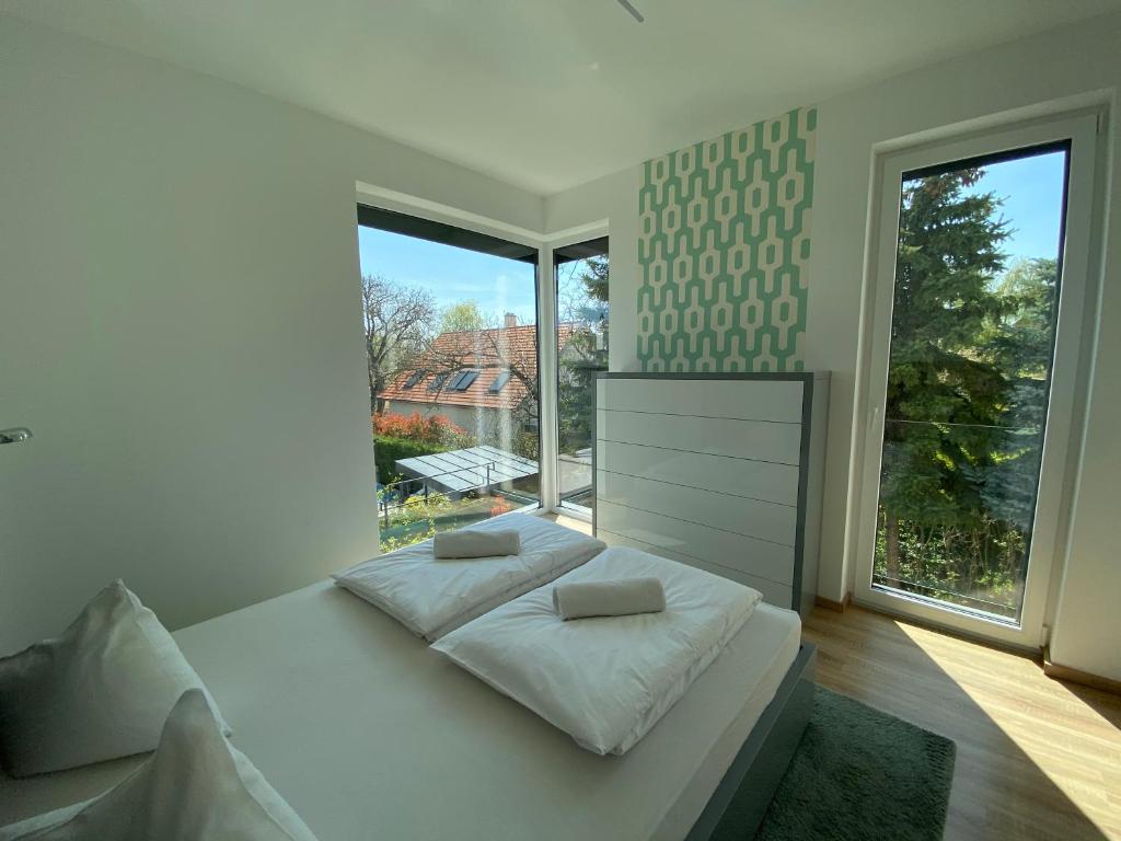 a white bedroom with a bed and a large window at Luxury Garden House II In The Center in Balatonfüred