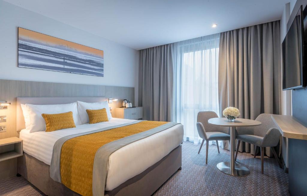una habitación de hotel con una cama grande y una mesa en Maldron Hotel Newcastle, en Newcastle