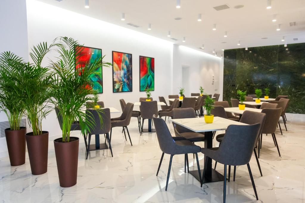 a restaurant with tables and chairs and potted plants at N Hotel BY NOSHI in Rinas