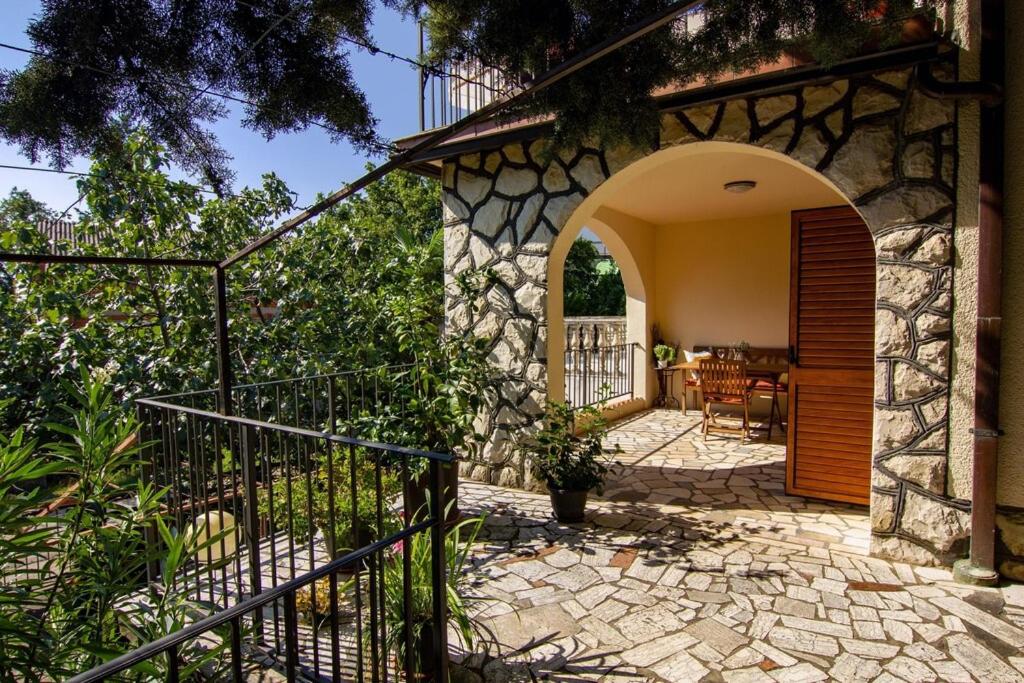 a stone house with a gate and a patio at Smokvica - Feigenbaum in Kornić