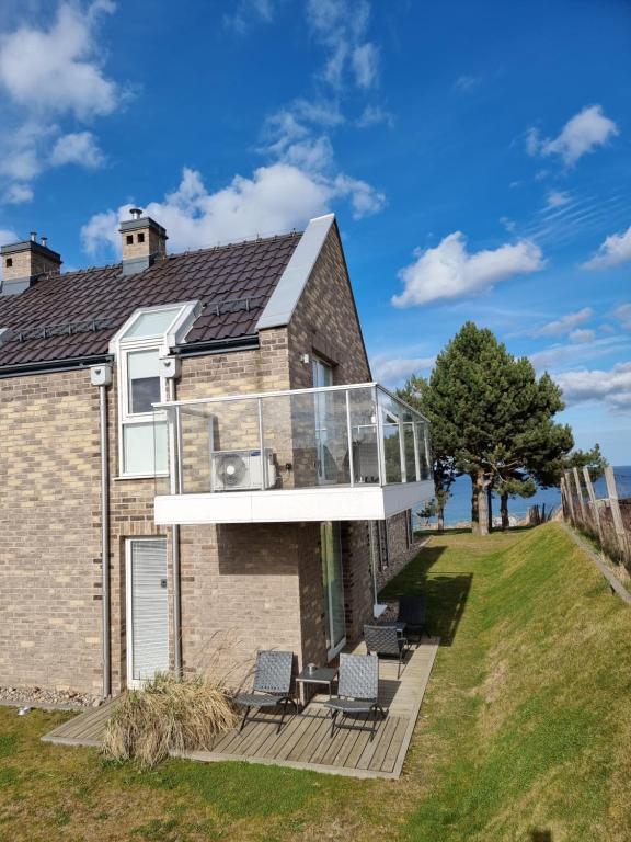 una casa con un balcone in vetro sul lato di Apartament Vespa a Mechelinki