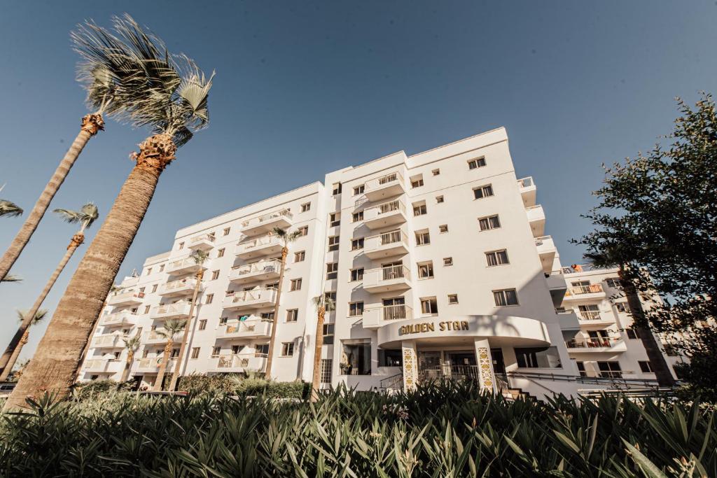 un edificio blanco con una palmera delante en Golden Star Beach en Protaras