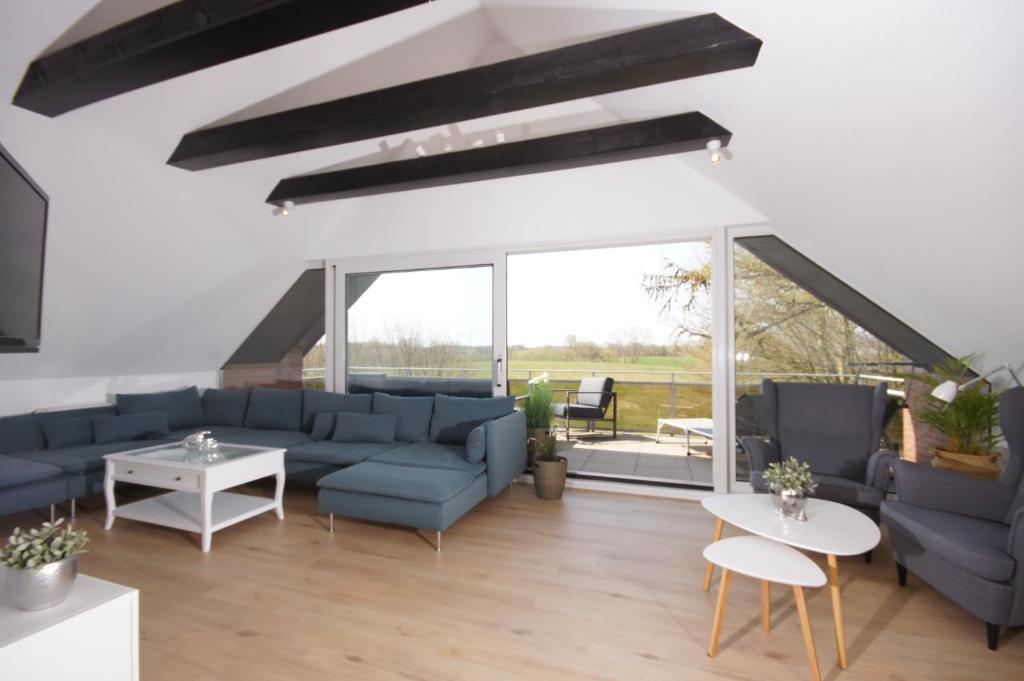 a living room with blue couches and a large window at Ferienhaus I Weitblick in Grömitz