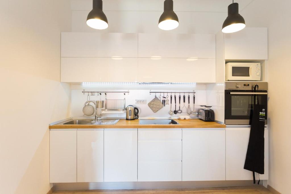 uma cozinha branca com armários e electrodomésticos brancos em Apartment Miško em Dubrovnik