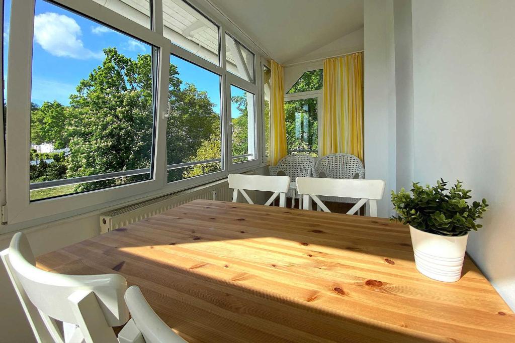 een eetkamer met een houten tafel en witte stoelen bij Villa Meeresgruss FeWo 9 in Ostseebad Sellin