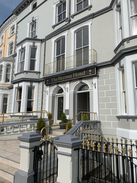 a white building with a fence in front of it at Baytree Hotel in Llandudno