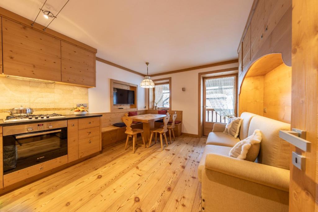 uma cozinha e sala de jantar com um sofá e uma mesa em Cadin Apartment em Cortina dʼAmpezzo