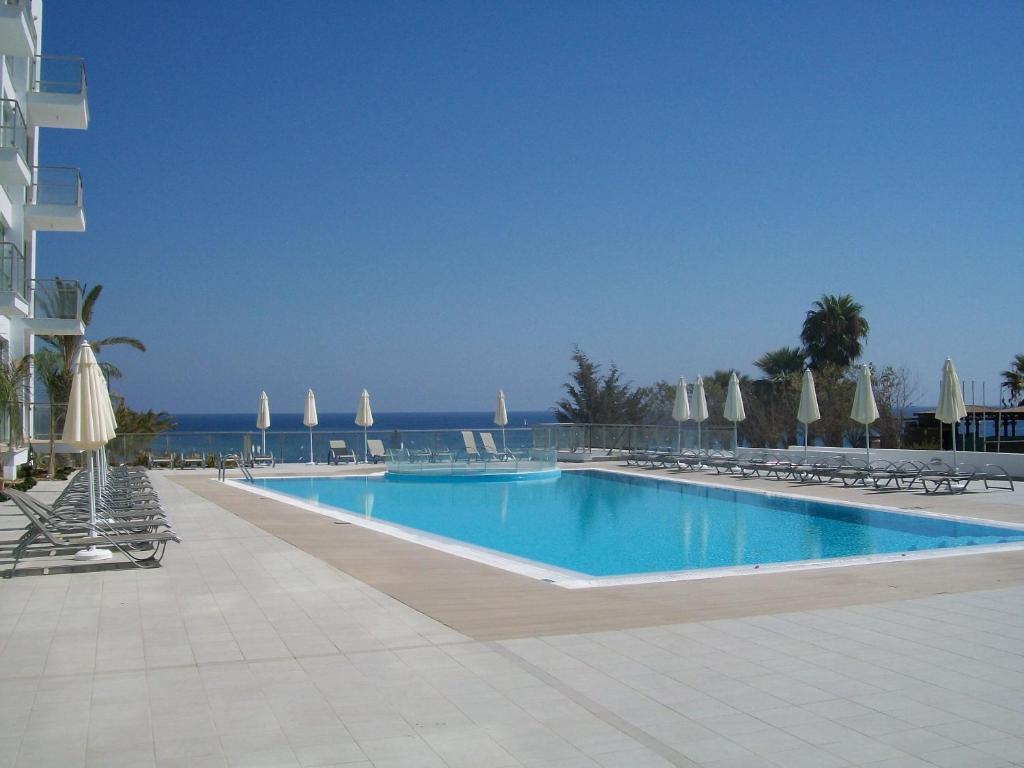 une grande piscine avec des chaises et des parasols dans l'établissement A209 Coralli Spa, Cyprus - Med View Studio, à Protaras