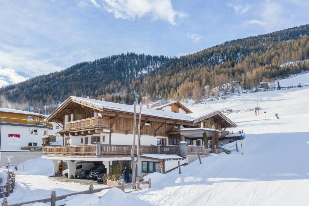 eine Skihütte im Schnee mit einem Berg in der Unterkunft Am Trogwohl in Sölden