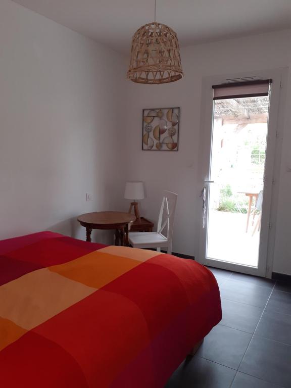 1 dormitorio con cama, mesa y ventana en Chambre privée au coeur d'une pinède dans un quartier résidentiel, en Lézignan-Corbières