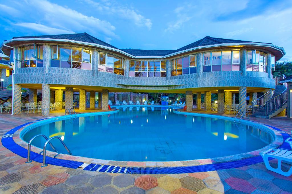 a large swimming pool in front of a building at Nokras Riverine Hotel & Spa in Sagana