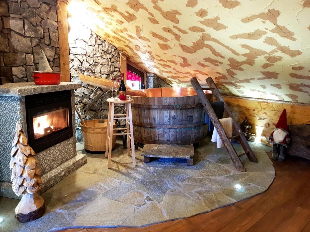 um quarto com uma banheira de madeira e uma lareira em ALLA STALLA Suite & Chalet em Piazzatorre