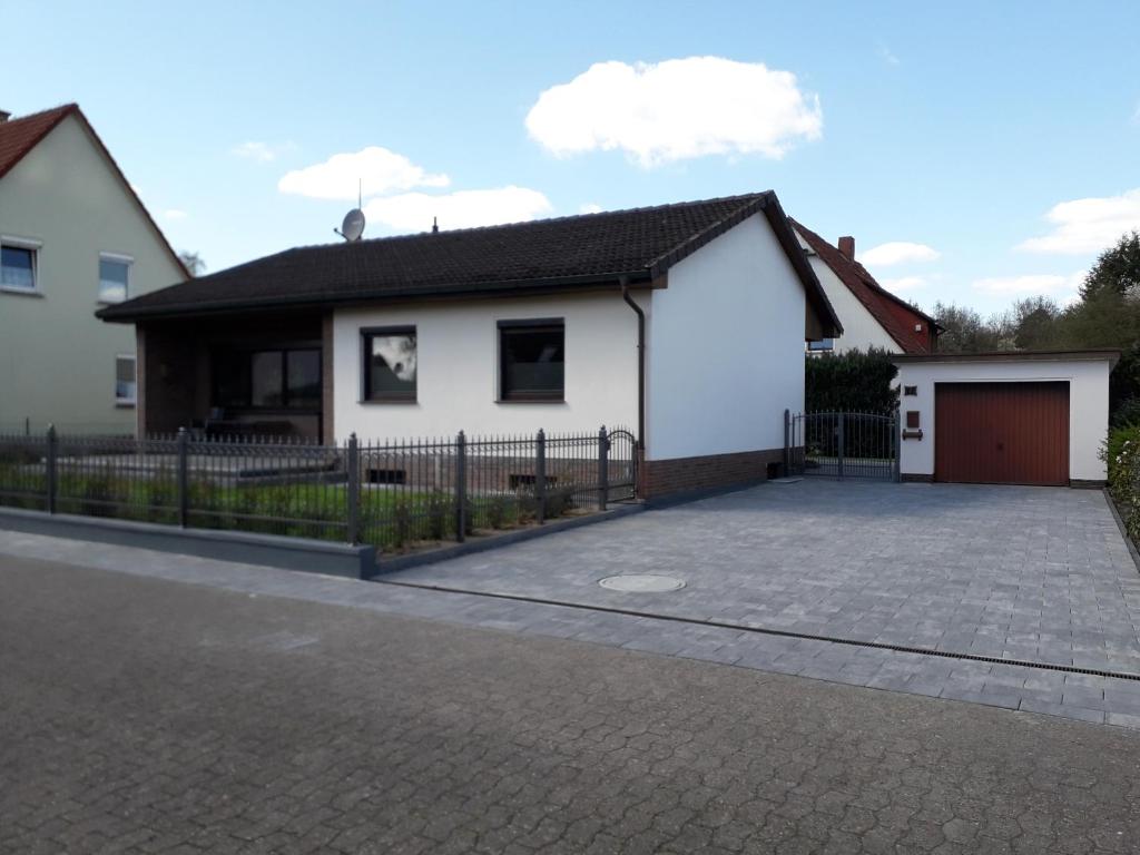 ein weißes Haus mit einer Einfahrt davor in der Unterkunft Heidehaus Hodenhagen in Hodenhagen
