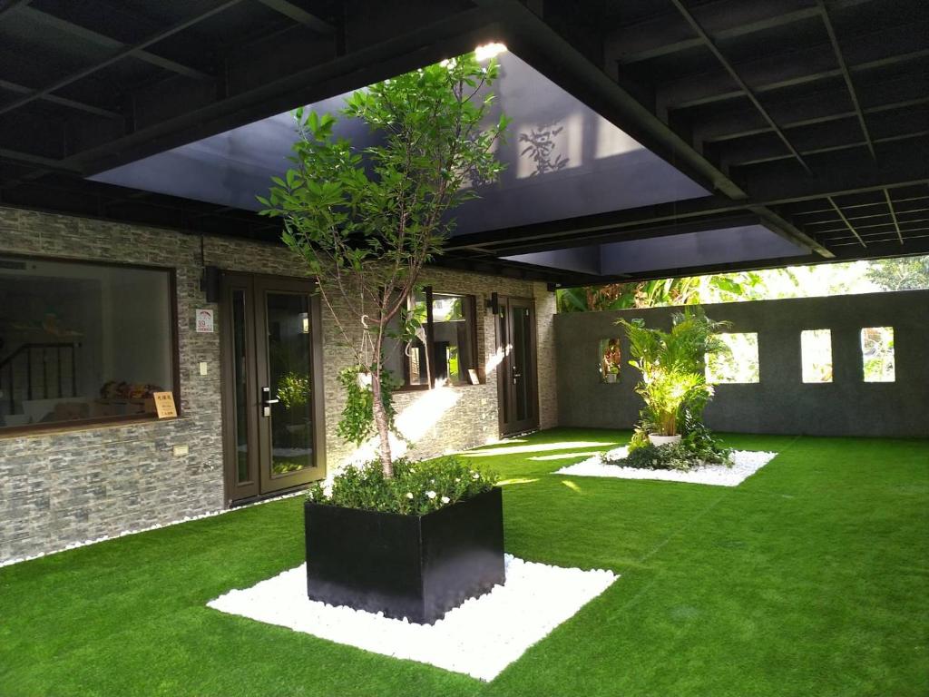 a garden with green grass and a house at 9 Tan Yuan Homestay in Jiaoxi