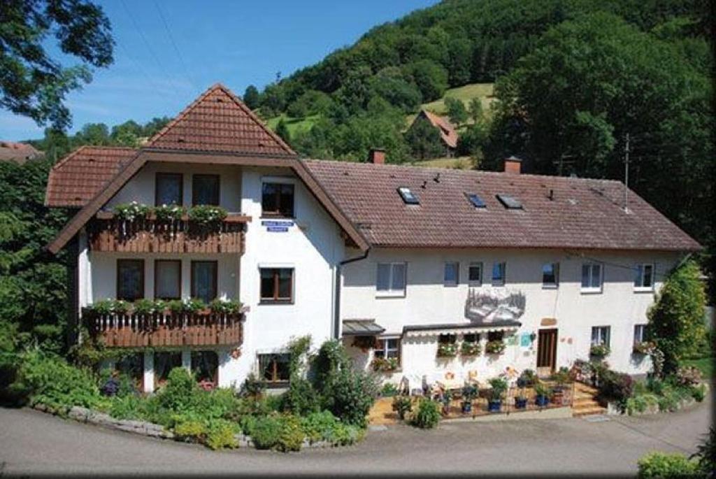 una gran casa blanca con flores en los balcones en Pension Schneider, en Freiamt