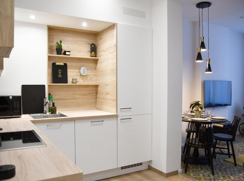 une cuisine avec des placards blancs et une petite table dans l'établissement Appartement au centre de Jambes-Namur Sleep & Repeat, à Jambes