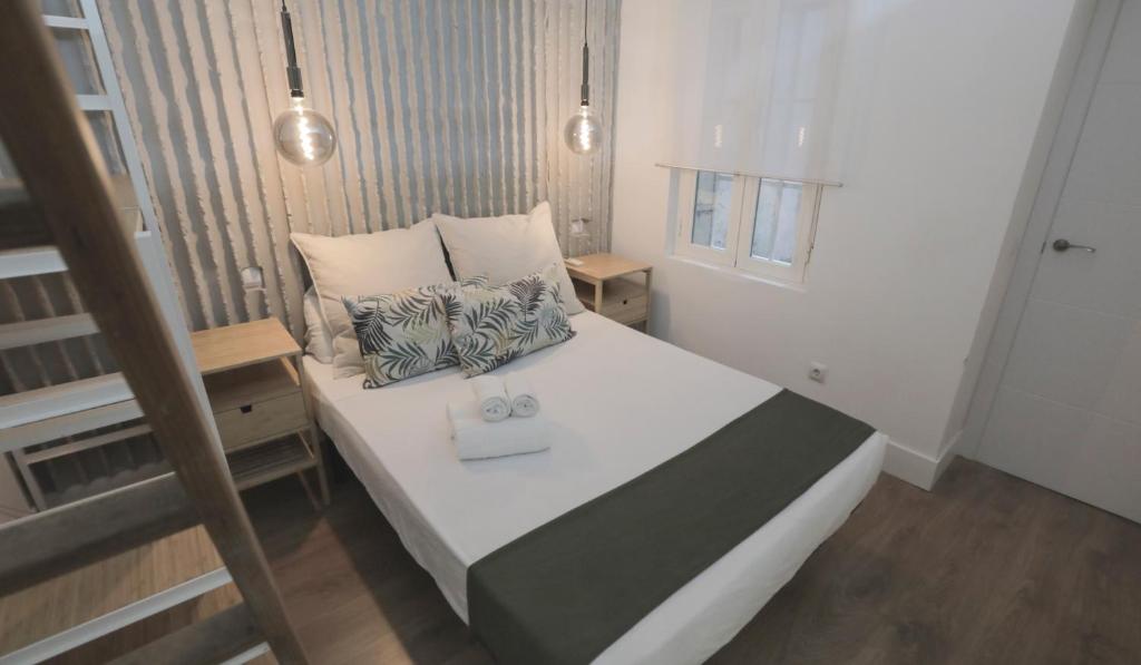 a small bedroom with a white bed with two pillows at Apartamento Malasaña II in Madrid