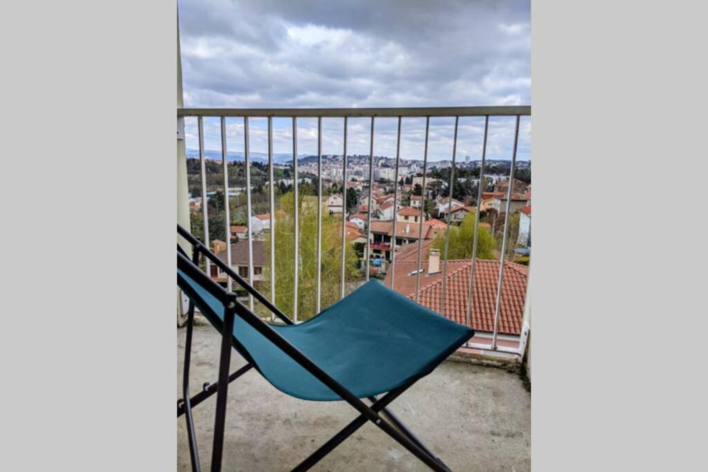 a blue chair sitting on a balcony with a view at Saint-Etienne Appart&#39;hôtel de Bellevue in Saint-Étienne