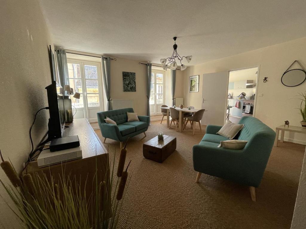 - un salon avec deux chaises vertes et une table dans l'établissement « Le traversin » Centre Sarlat App. 2 chambres, à Sarlat-la-Canéda