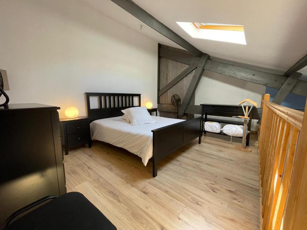 サン・テミリオンにあるLes logis des Vignobles Saint Emilion en Duplex n 2 avec terrasseのベッドルーム(ベッド1台、天窓付)