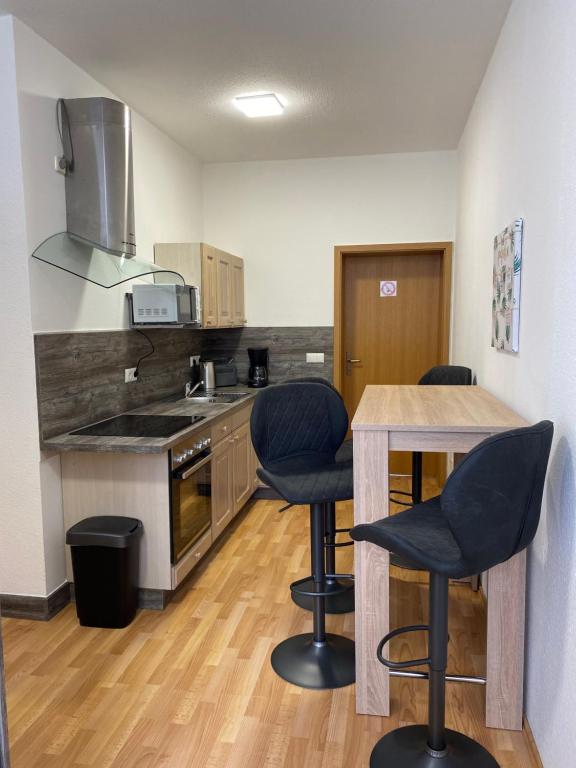 a kitchen with chairs and a table in a room at Ferienwohnung H&M Immobilien Alsleben 2 in Alsleben