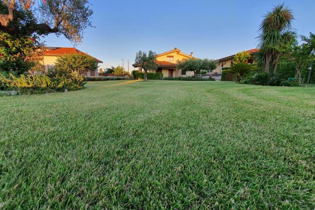 オルトーナにあるVilletta Giardino degli Uliviの家の前に緑の芝生が広がる庭