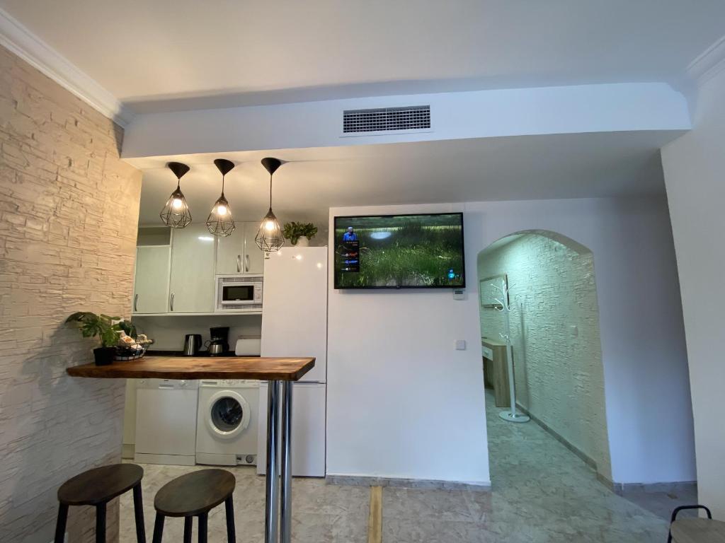cocina con encimera y taburetes en una habitación en TarracoHomes, TH134 Apartamento Llorer, en Tarragona