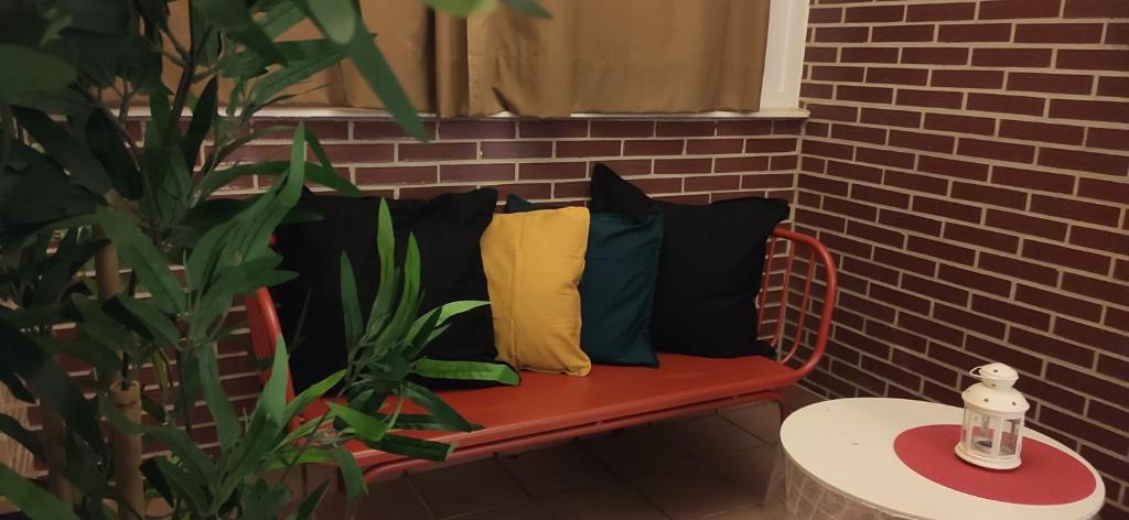 un banc avec des oreillers à côté d'un mur en briques dans l'établissement INSIDEHOME Apartments - El Capricho de Elsa, à Unquera