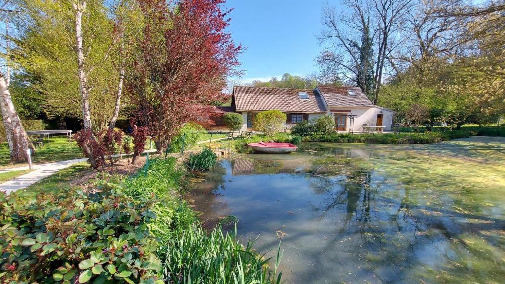 a house with a pond in the yard at La petite campagne in Blaru