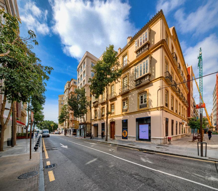 an empty city street with a yellow building at Holidays2Malaga Soho Penthouse in Málaga