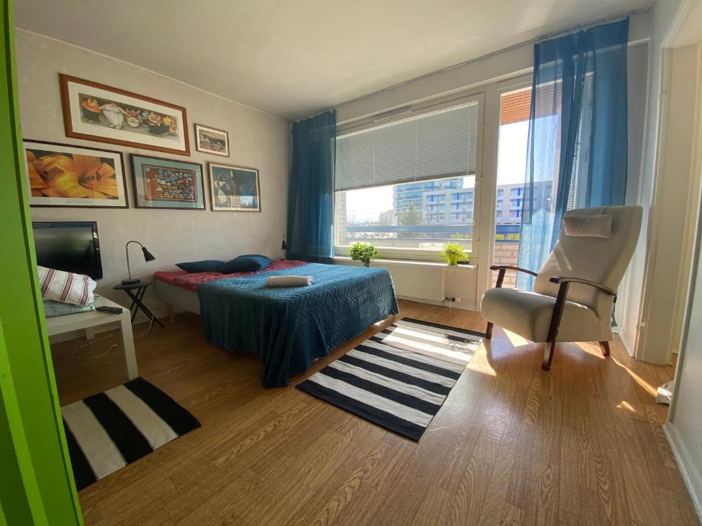 um quarto com uma cama, uma cadeira e uma janela em Kiva majoitus 1-4hlö, 500m keskustaan, parkkipaikka em Oulu
