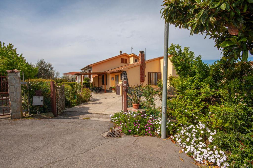 una casa con una valla y flores delante de ella en Vacanze Maria Stella, en Pescia Romana