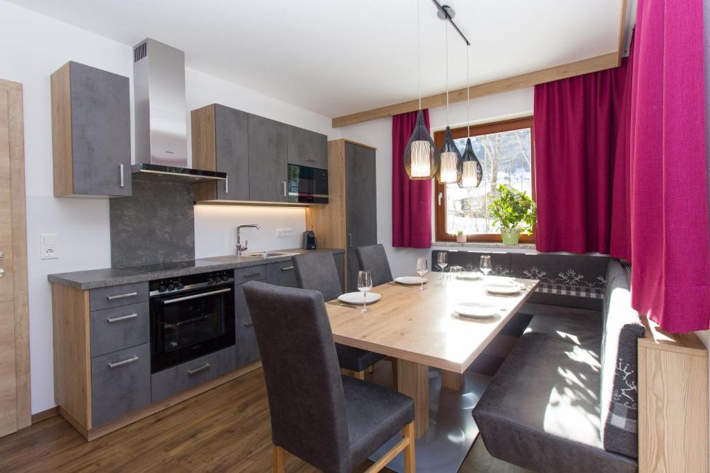 a kitchen with a wooden table and purple curtains at Reinthalers in Werfenweng