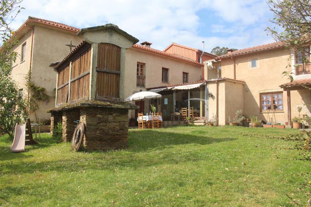 a large house with a grass yard in front of it at Casa Pousadoira in Miño