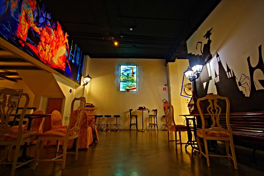 a room with chairs and tables and a stained glass window at All Iron Hostel in Bilbao