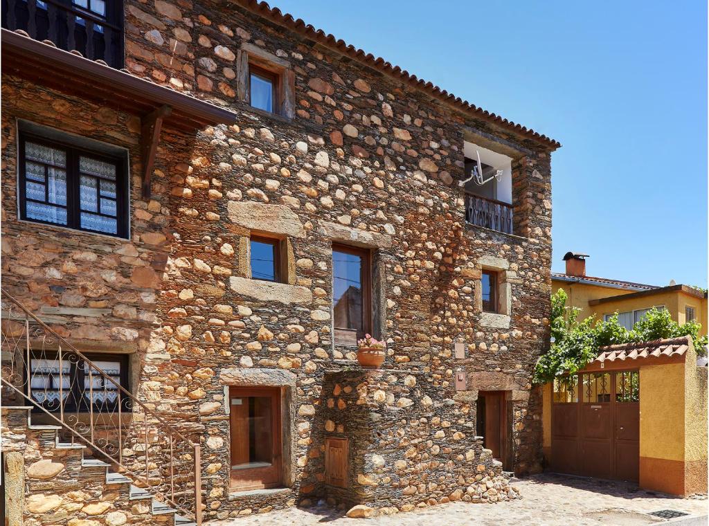 an old stone building with a staircase on it at Casa da Pedra Rolada in Janeiro de Cima