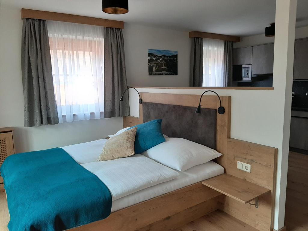 a bedroom with a bed with a blue blanket on it at Apartments by Pension Ballwein in Salzburg