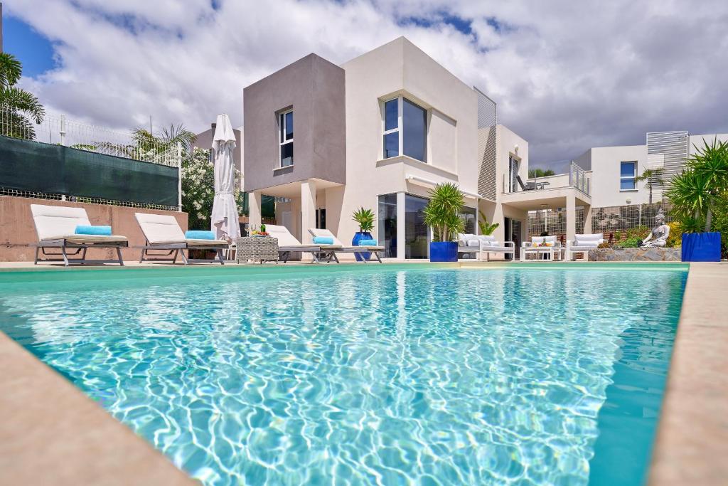 una villa con piscina di fronte a una casa di Villa Flamencos Rosas, Costa Adeje a Playa Paraiso