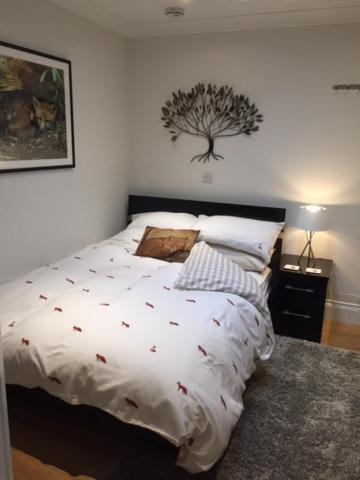 a bedroom with a bed with a tree on the wall at Foxes Den at Foxesway in Kirkby on Bain