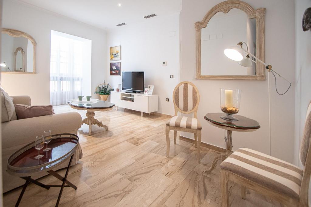 een woonkamer met een bank en een tafel bij Apartamento Garum in Cádiz