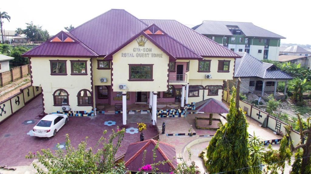 a house with a car parked in front of it at Gya-son Royal Guest House in Kumasi