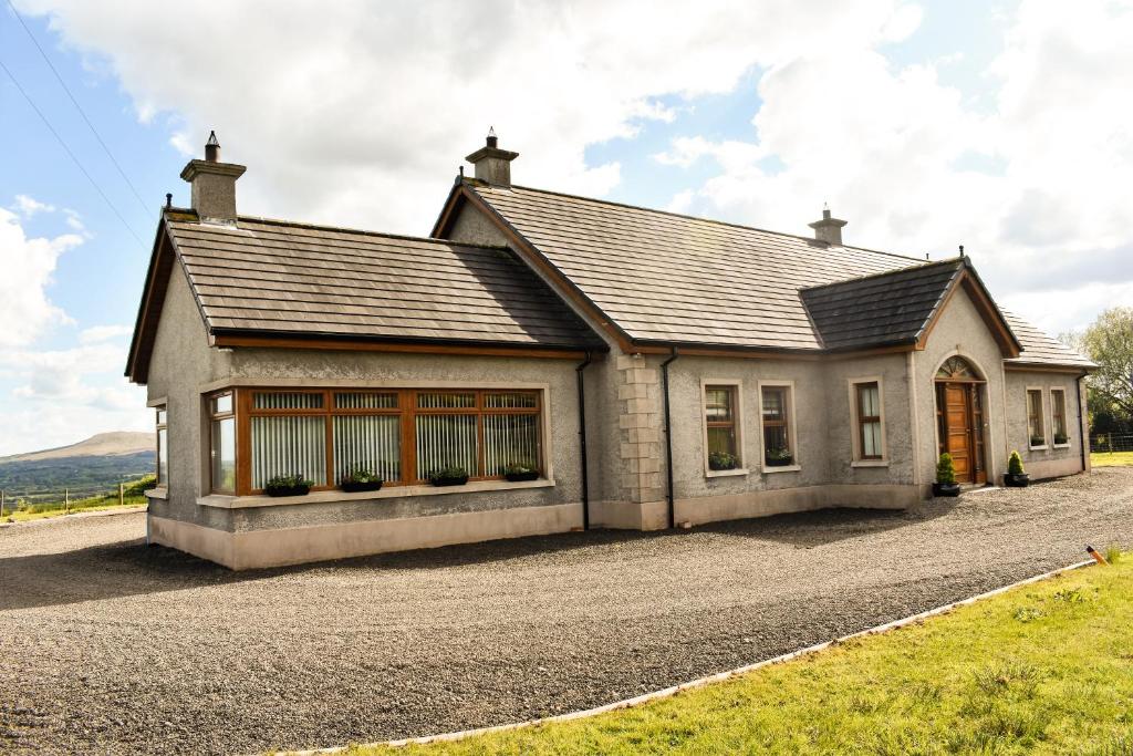 a house on a gravel road in front at Glenshane Country House in Maghera