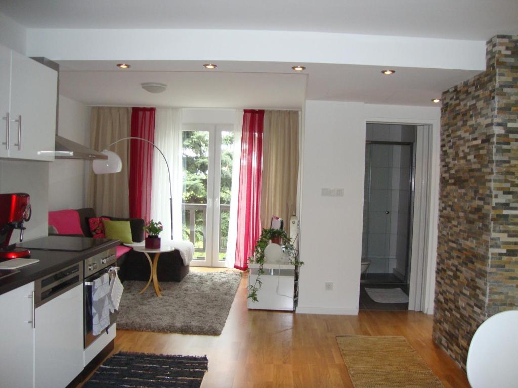 uma cozinha e sala de estar com cortinas vermelhas em Hanna Apartment em Viena