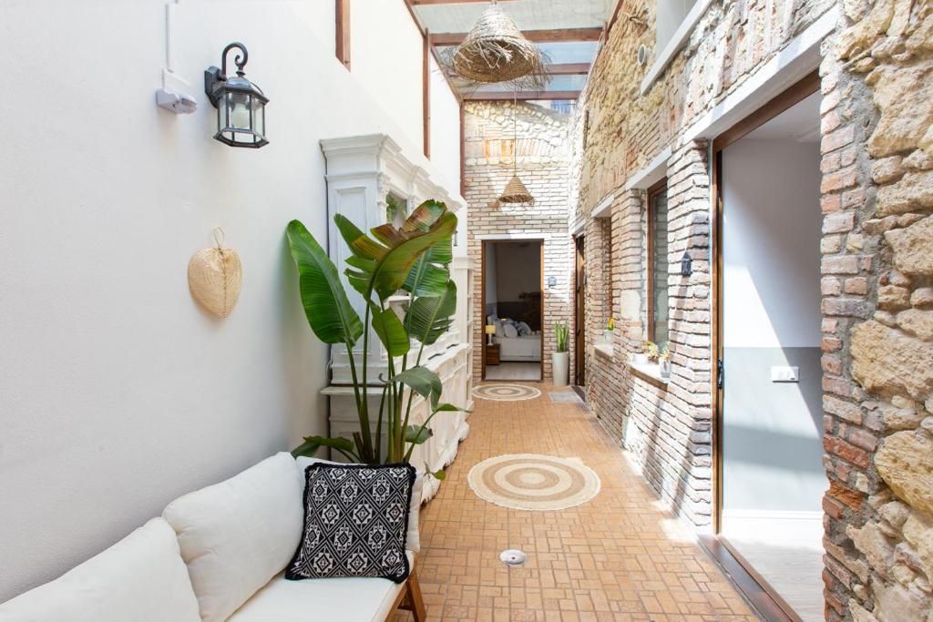 a hallway with a couch and a potted plant at Maison Garibaldi in Cagliari
