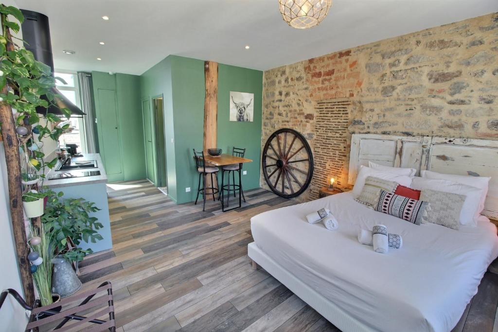 - un salon avec un lit blanc et un mur en briques dans l'établissement Appartement centre-ville avec terrasse RUSTIQUE, à Vannes