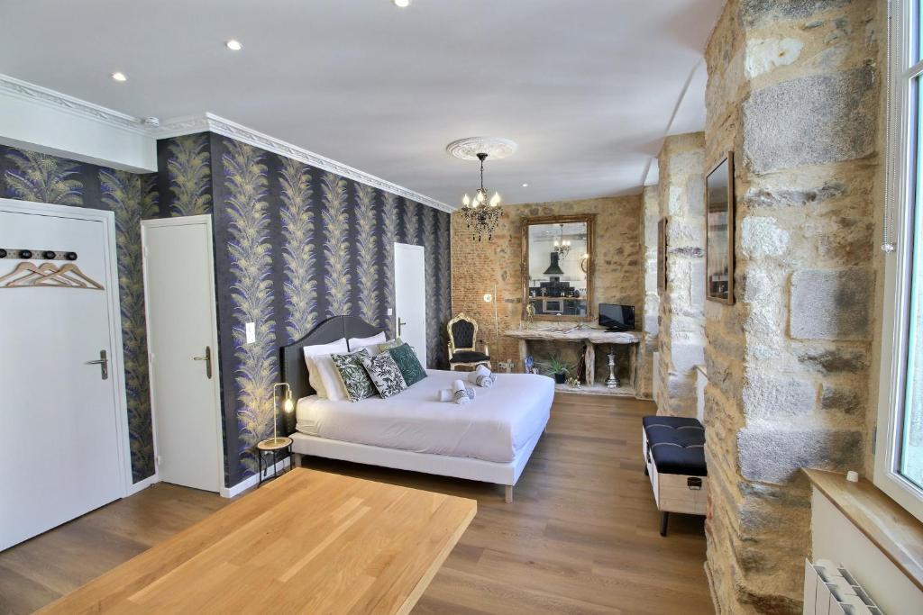 ein Schlafzimmer mit einem weißen Bett und einer Steinmauer in der Unterkunft Appartement centre-ville CHIC in Vannes
