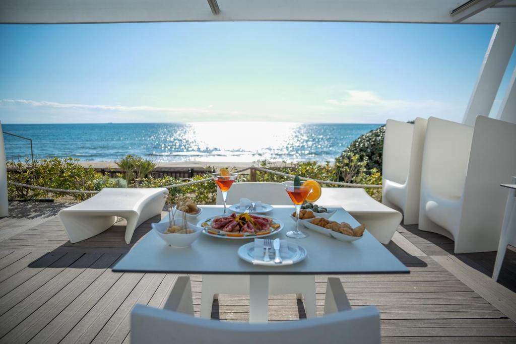 a table with food and a view of the ocean at Hotel Oasi Di Kufra in Sabaudia