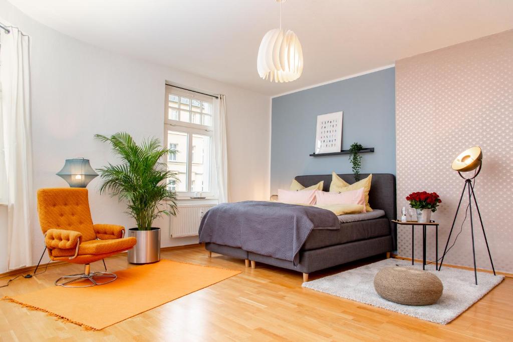 a bedroom with a bed and a chair and a couch at Kaßberg Apartment im Retro-Stil / Netflix & WIFI in Chemnitz