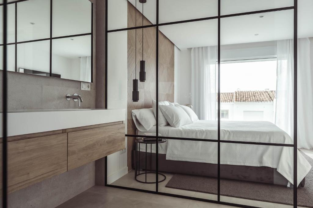 y baño con cama, lavabo y espejo. en Exclusive House located in Prime location, en Marbella